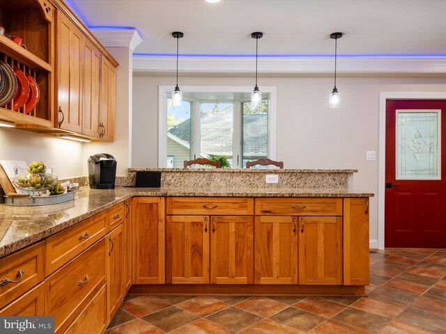 kitchen with light stone counters, decorative light fixtures, and kitchen peninsula