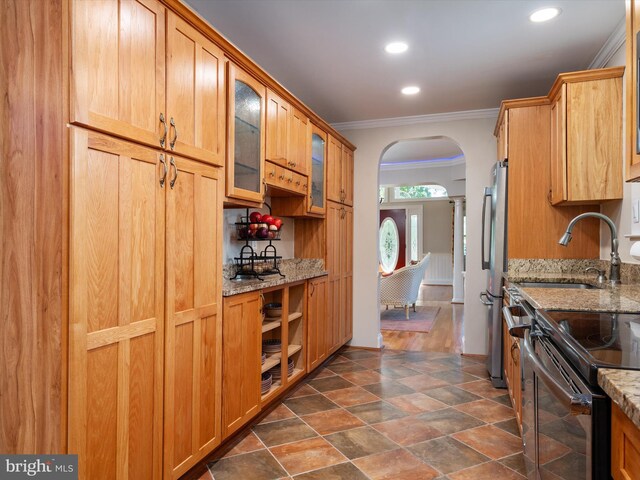 kitchen featuring ornamental molding, light stone countertops, appliances with stainless steel finishes, and dark hardwood / wood-style flooring