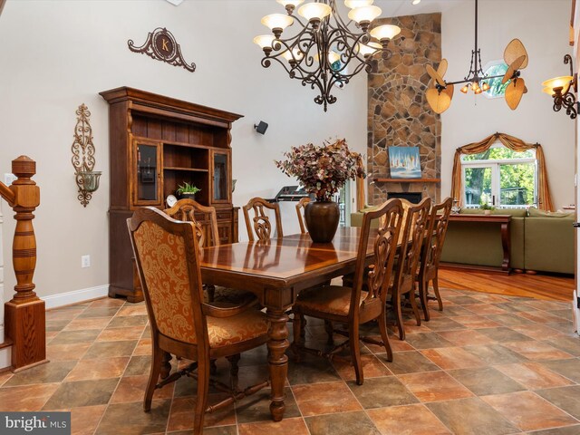 dining area featuring a fireplace and a notable chandelier