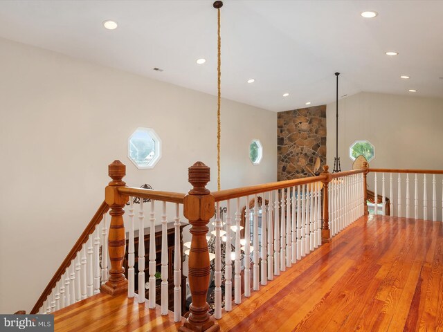 staircase with vaulted ceiling and hardwood / wood-style floors