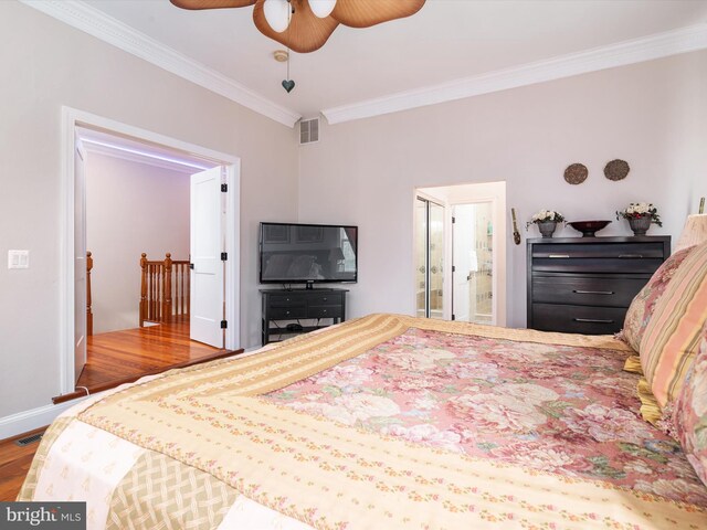 bedroom with crown molding, connected bathroom, ceiling fan, and hardwood / wood-style flooring