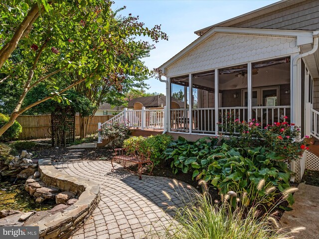 view of patio with a wooden deck and a sunroom