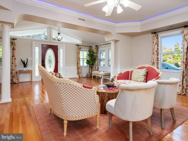 living room featuring decorative columns, crown molding, ceiling fan, and light hardwood / wood-style floors