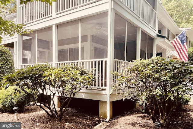 view of side of property with a balcony and a sunroom