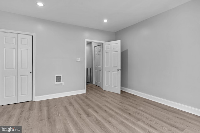 unfurnished bedroom with light hardwood / wood-style flooring and a closet