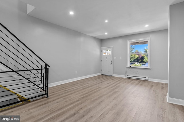 entrance foyer with a baseboard heating unit and light hardwood / wood-style floors