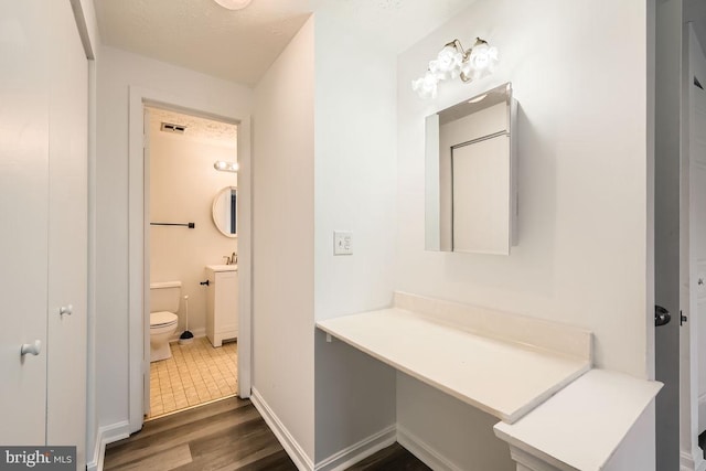 bathroom featuring hardwood / wood-style floors, vanity, and toilet