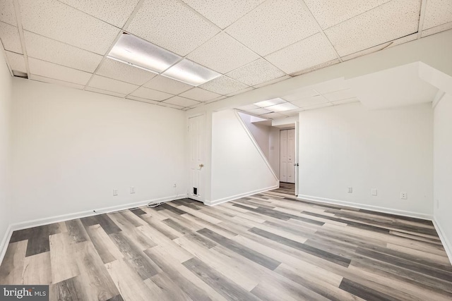 basement with a drop ceiling and light hardwood / wood-style floors