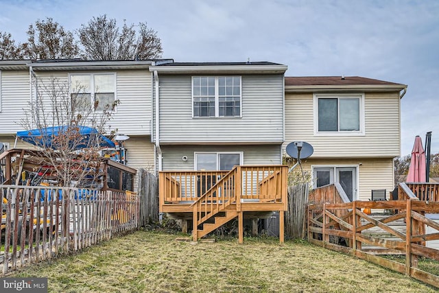 rear view of house with a deck and a yard