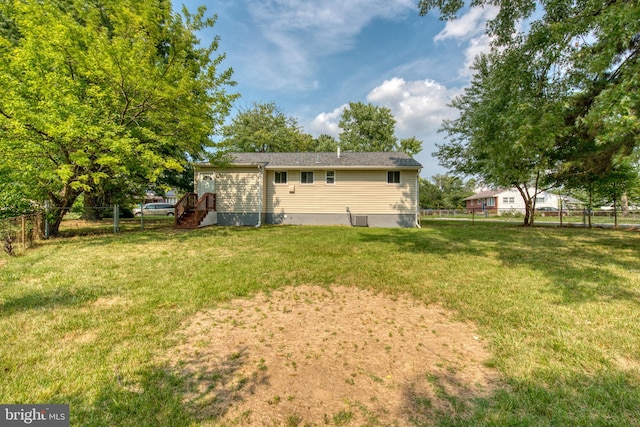 rear view of house featuring a lawn and central AC