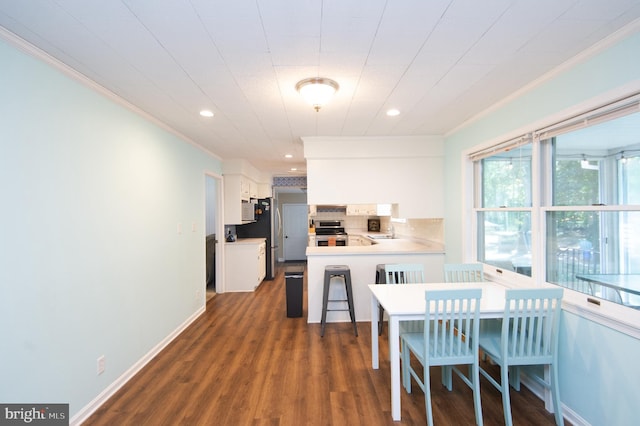 dining room with dark wood-type flooring, crown molding, and sink