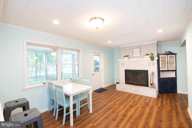 living room featuring ornamental molding, a brick fireplace, and dark hardwood / wood-style floors