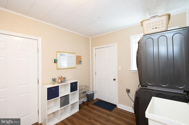 foyer featuring stacked washer and clothes dryer, ornamental molding, and dark hardwood / wood-style flooring