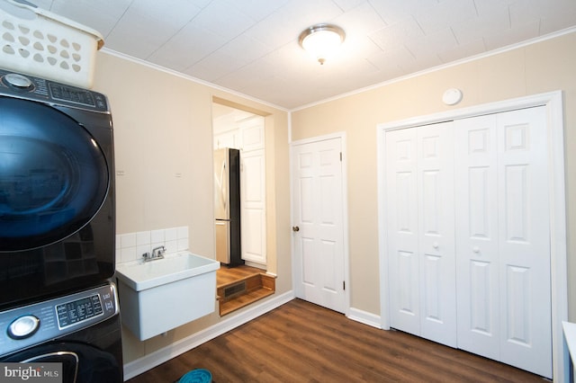 laundry area with crown molding, dark hardwood / wood-style floors, sink, and stacked washer and dryer