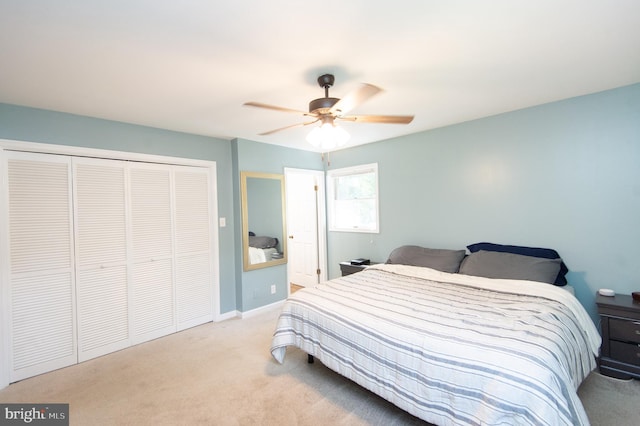 bedroom with light colored carpet, ceiling fan, and a closet