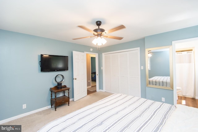 bedroom featuring light colored carpet, connected bathroom, a closet, and ceiling fan