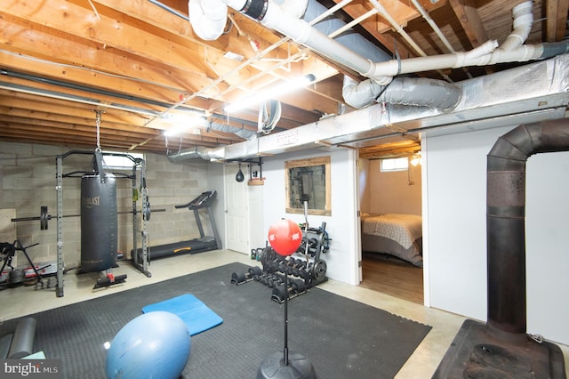 exercise area with a healthy amount of sunlight, water heater, and concrete floors