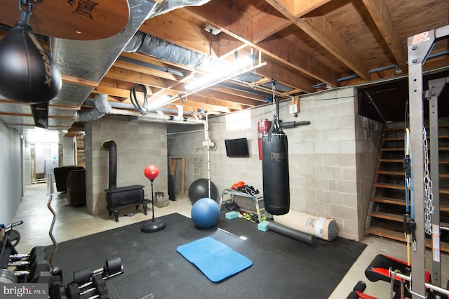 exercise room with concrete flooring and a wood stove