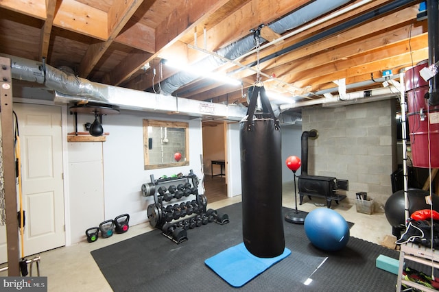 workout room featuring a wood stove and concrete floors