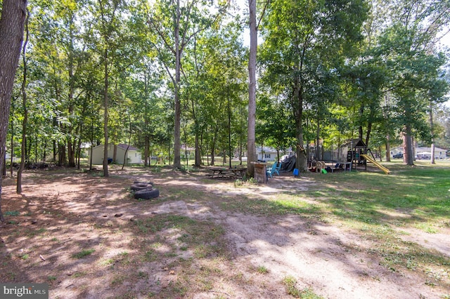 view of yard featuring a storage shed and a playground