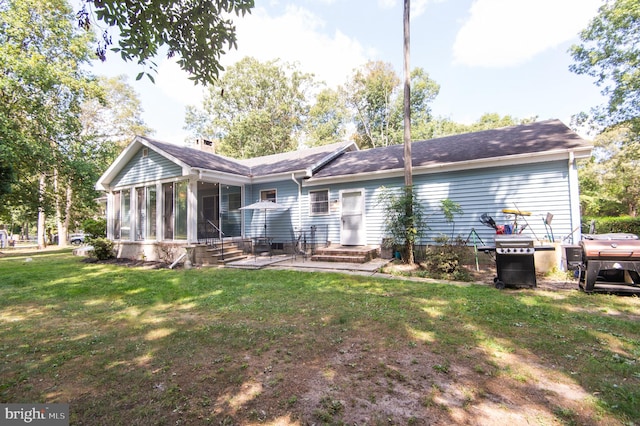 back of house with a lawn, a patio, and a sunroom