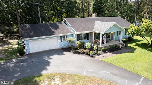 view of front facade with a garage, a front yard, and a porch