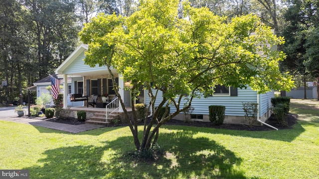 back of house with a porch and a lawn