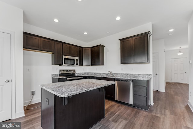 kitchen featuring appliances with stainless steel finishes, a center island, dark hardwood / wood-style floors, and sink