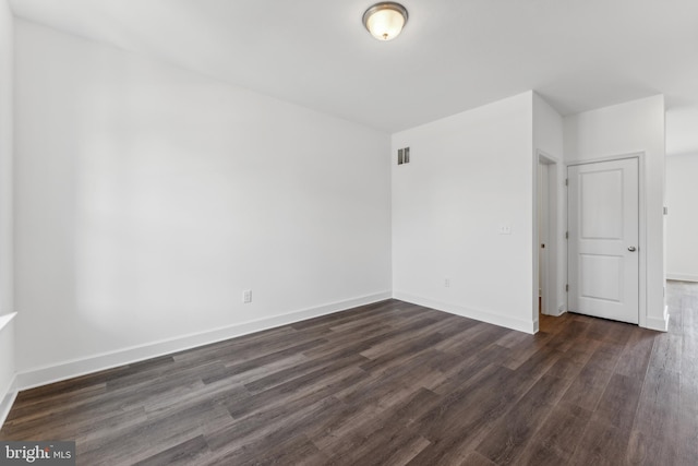 spare room with dark hardwood / wood-style flooring