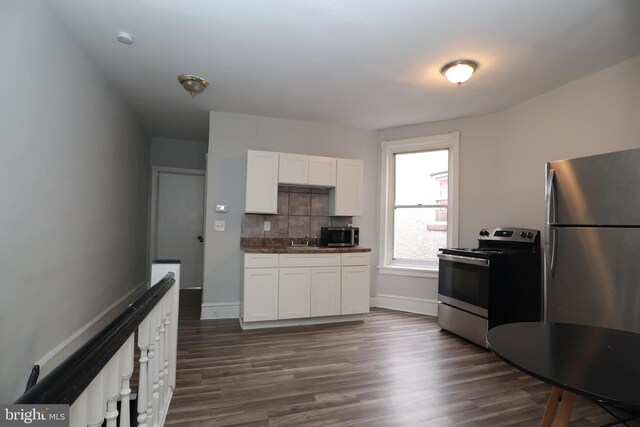 kitchen with white cabinets, stainless steel appliances, dark hardwood / wood-style flooring, and tasteful backsplash