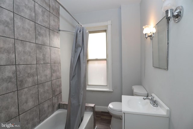 full bath featuring shower / tub combo with curtain, toilet, wood finished floors, baseboards, and vanity