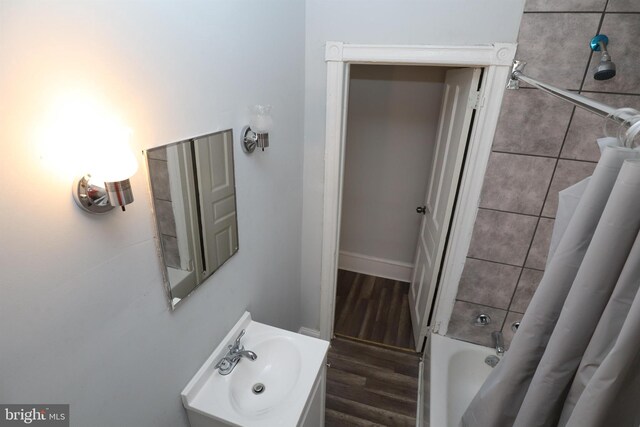 bathroom featuring wood-type flooring, shower / tub combo, and sink