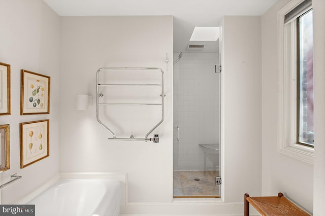 bathroom featuring a healthy amount of sunlight and shower with separate bathtub