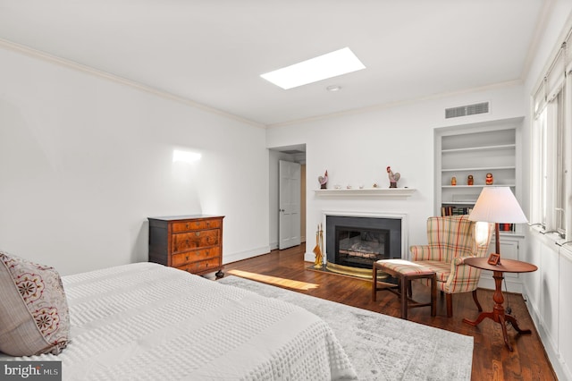 bedroom featuring dark hardwood / wood-style flooring, a skylight, and ornamental molding