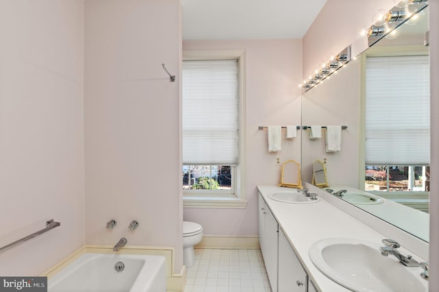 bathroom with vanity, toilet, and a tub