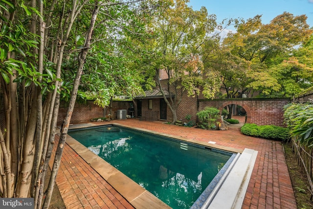 view of swimming pool featuring cooling unit and a patio