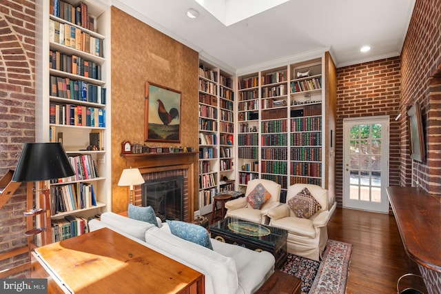 sitting room featuring crown molding, dark hardwood / wood-style flooring, brick wall, and a brick fireplace