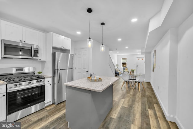 1710 Light St, Baltimore, MD 21230 - kitchen with appliances with stainless steel finishes, white cabinetry, a kitchen island, wood finished floors, and light stone countertops