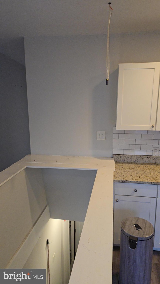 interior space with backsplash and hardwood / wood-style floors