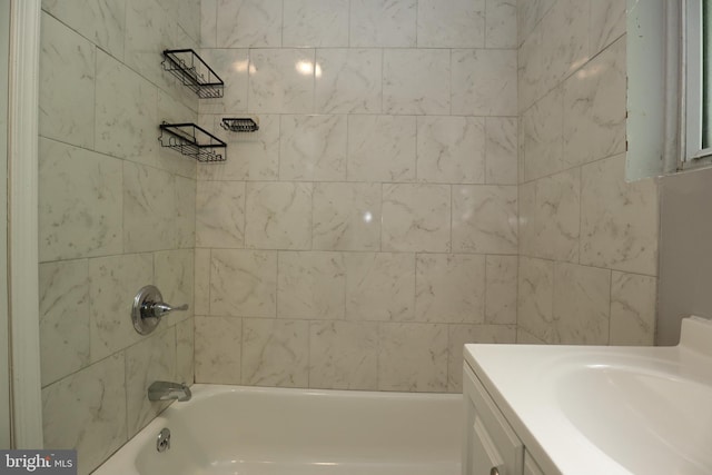 bathroom with tiled shower / bath and vanity