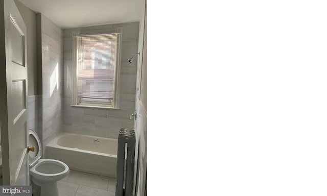 bathroom featuring toilet, tile patterned floors, and tiled shower / bath