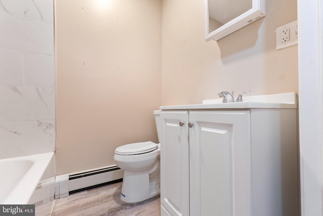 bathroom with a tub to relax in, vanity, wood-type flooring, toilet, and baseboard heating