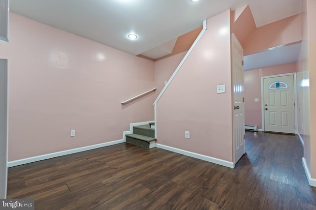 interior space with a baseboard heating unit and dark hardwood / wood-style flooring