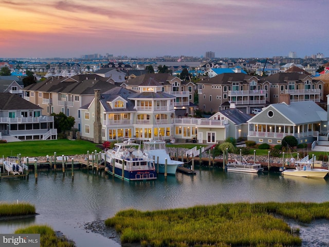 aerial view at dusk featuring a water view