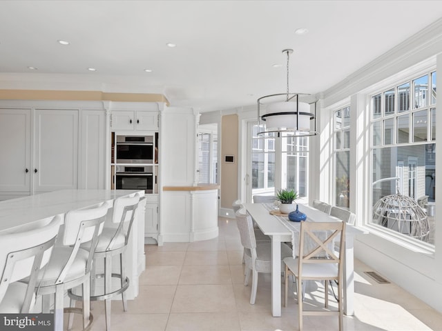 dining space featuring light tile patterned floors and crown molding