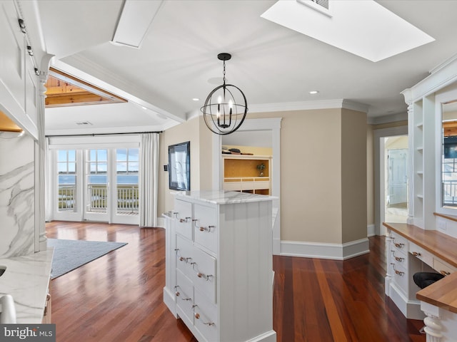 kitchen with crown molding, dark hardwood / wood-style flooring, white cabinets, and hanging light fixtures