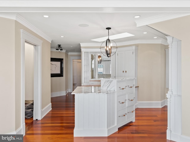 kitchen featuring decorative light fixtures, dark hardwood / wood-style flooring, and ornamental molding