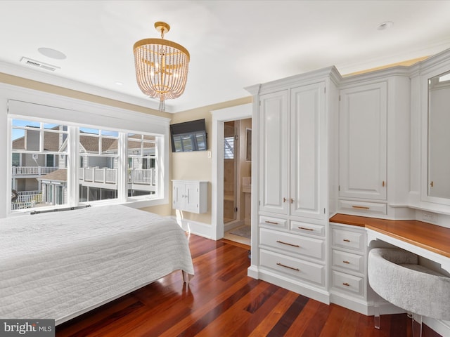 bedroom featuring an inviting chandelier, dark hardwood / wood-style floors, connected bathroom, and ornamental molding