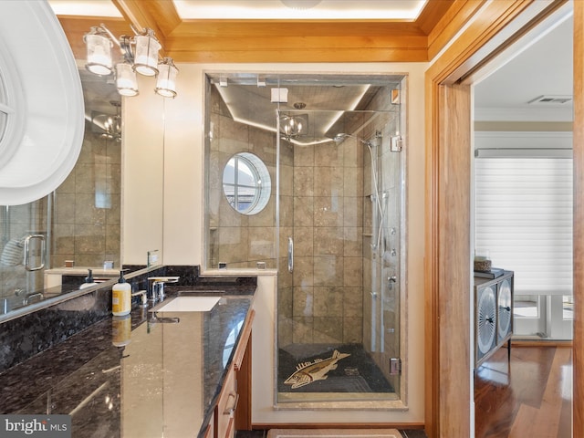 bathroom featuring ornamental molding, vanity, hardwood / wood-style flooring, and walk in shower