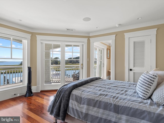 bedroom with dark wood-type flooring, ornamental molding, a water view, and access to outside